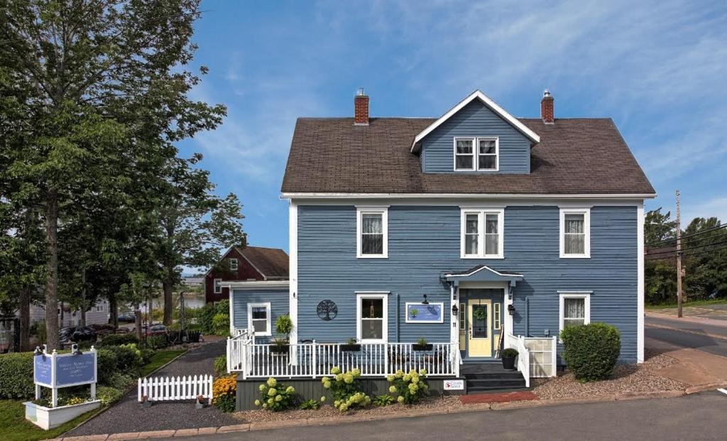 a blue house with a yellow door on a street at Willow House Inn B&B in Pictou