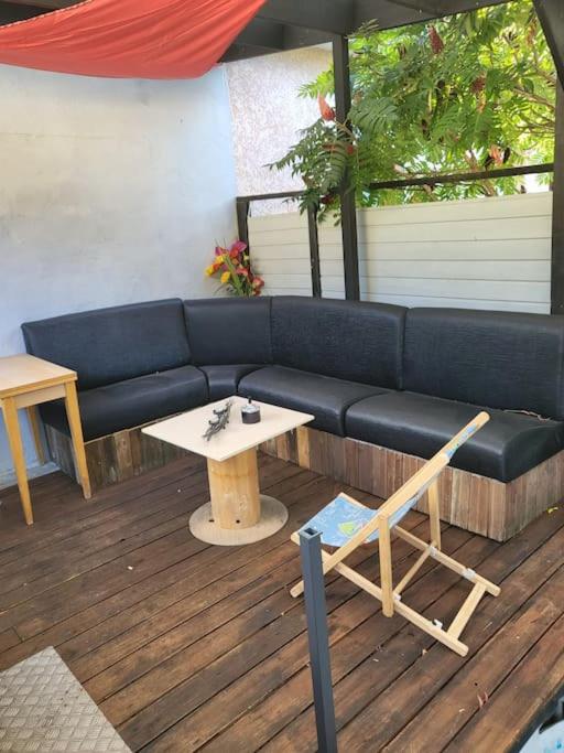 un canapé bleu assis sur une terrasse avec une table dans l'établissement Du bon temps, à Bôo-Silhen