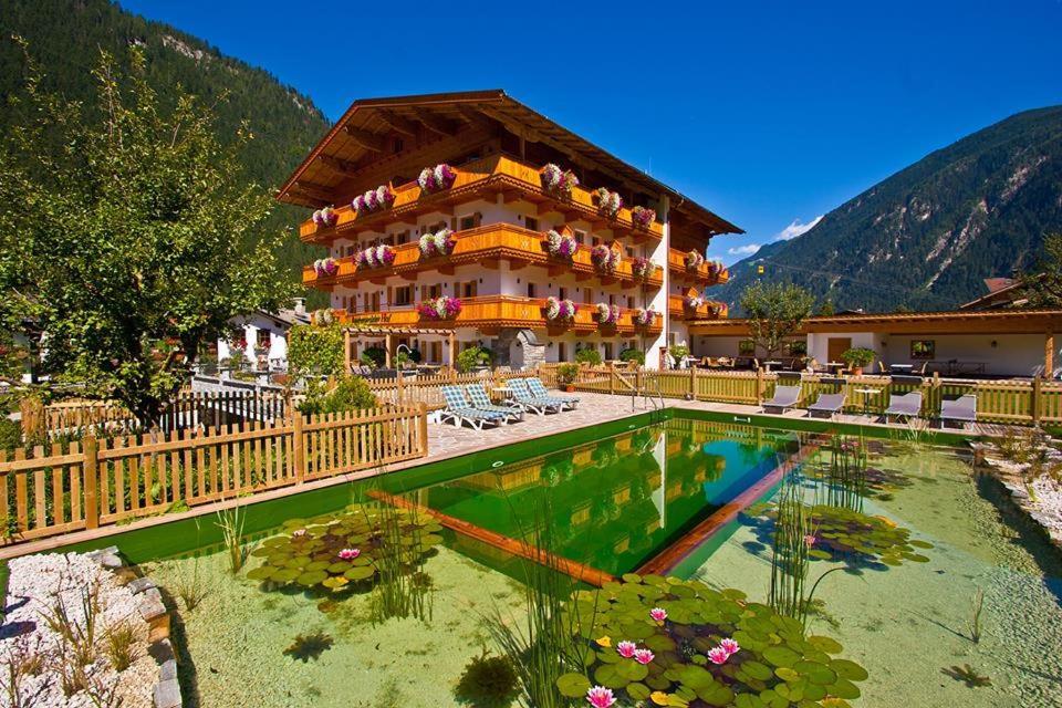 a hotel with a pool in front of a building at Landhotel Rauchenwalderhof in Mayrhofen