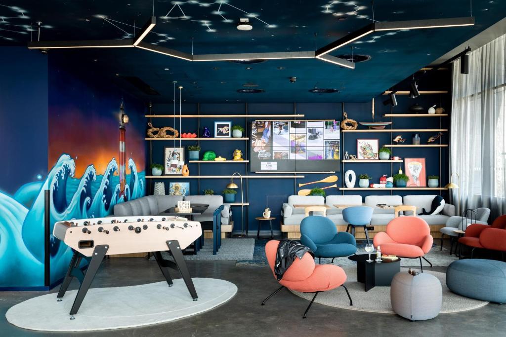 una sala de juegos con mesa y sillas en una habitación en Moxy Plymouth, en Plymouth