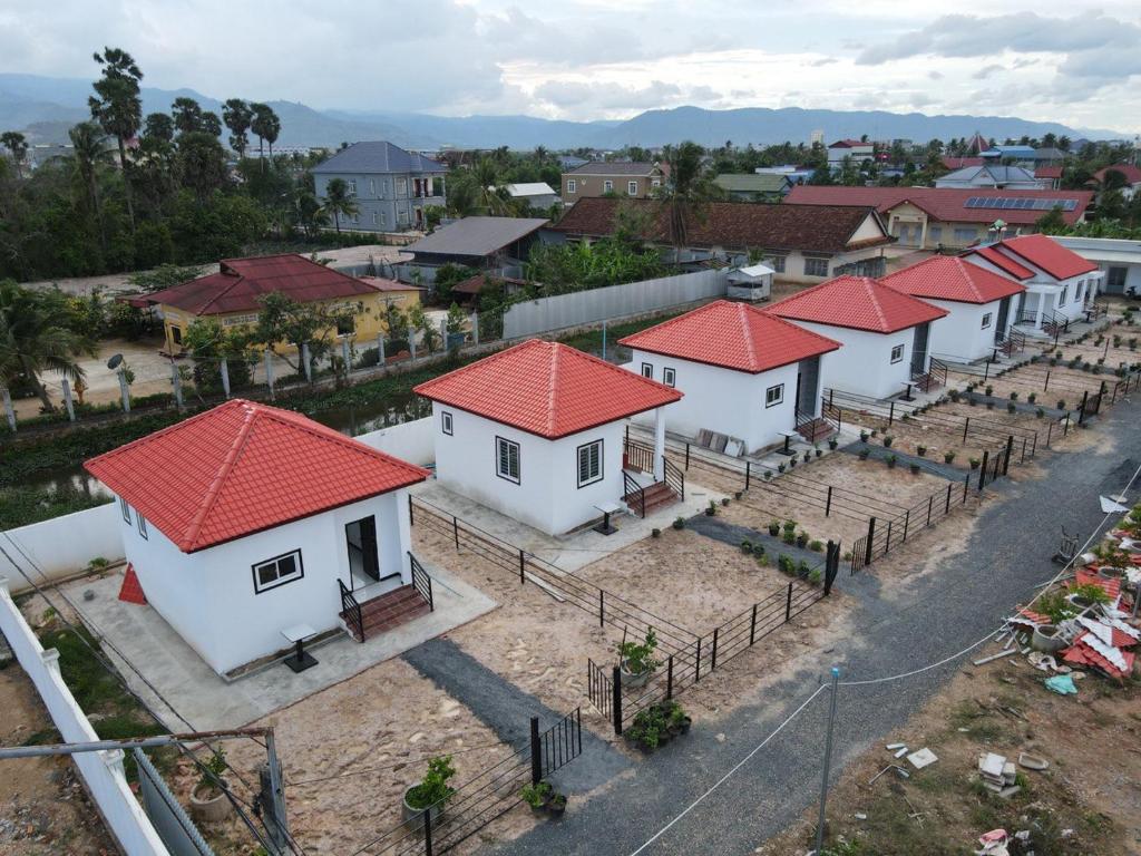 a row of houses with red roofs in a village at Home Daun Kam 1 in Kampot