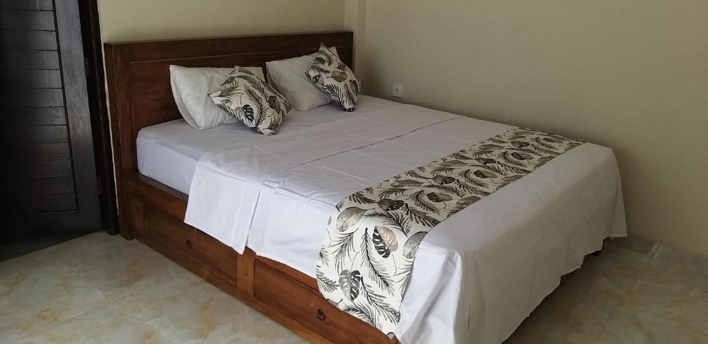 ein Bett mit weißer Bettwäsche und Kissen in einem Schlafzimmer in der Unterkunft Melanting Corner in Dalung