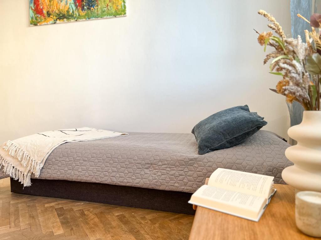 a bed with a pillow and a desk with a book at Cozy room near the city centre in Košice
