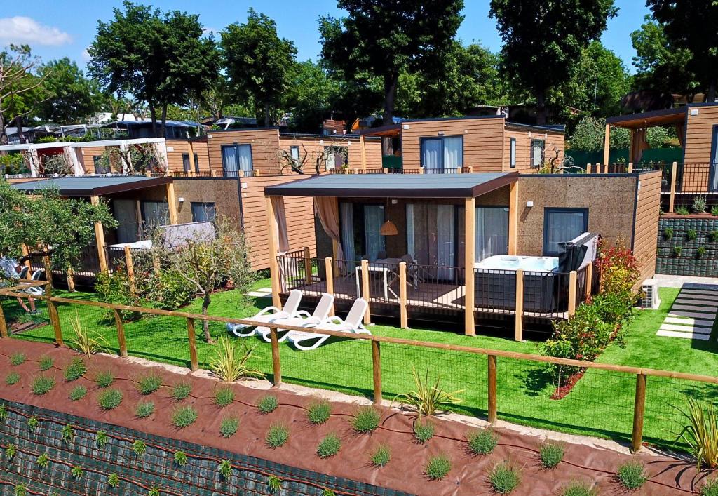 a house with a lawn with chairs and a fence at Camping Fossalta in Lazise