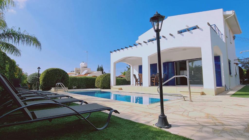 a villa with a swimming pool and a street light at STAY Calypso Villa in Peyia