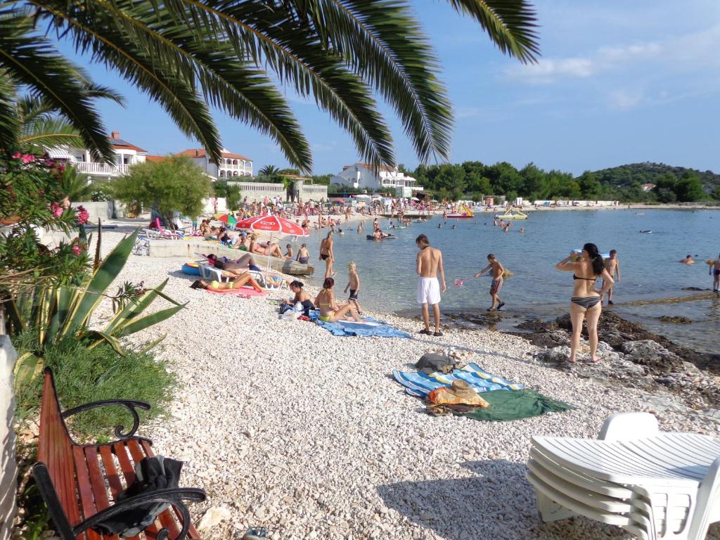 a group of people on a beach in the water at Villa Palas Apartments 2 in Rogoznica