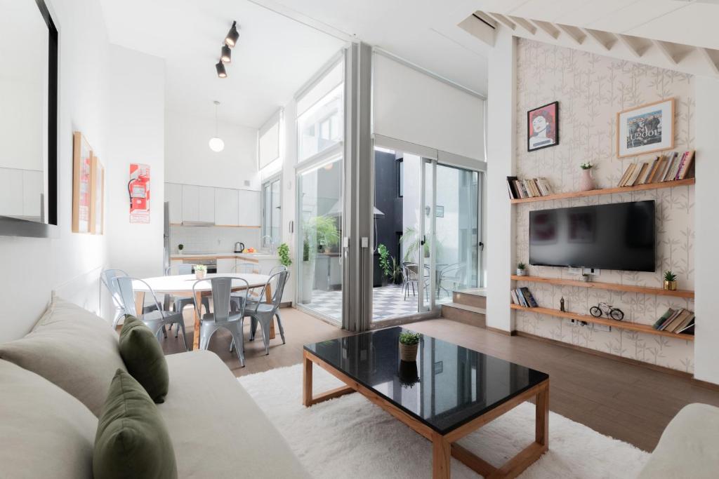 a living room with a couch and a table at Fliphaus Santa Fe 5100 - 3 Bd Pool & Bbq in Buenos Aires