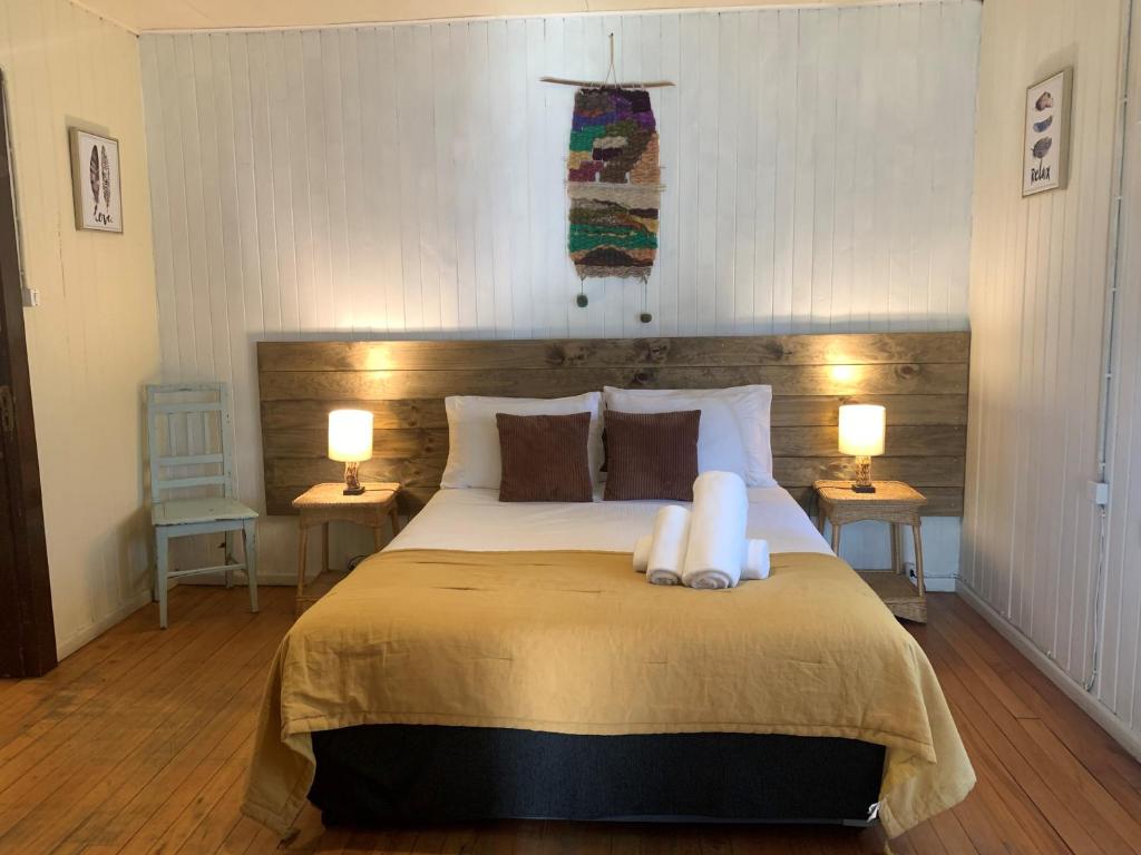 a bedroom with a large bed with two lamps at La Nuez BnB in Pucón