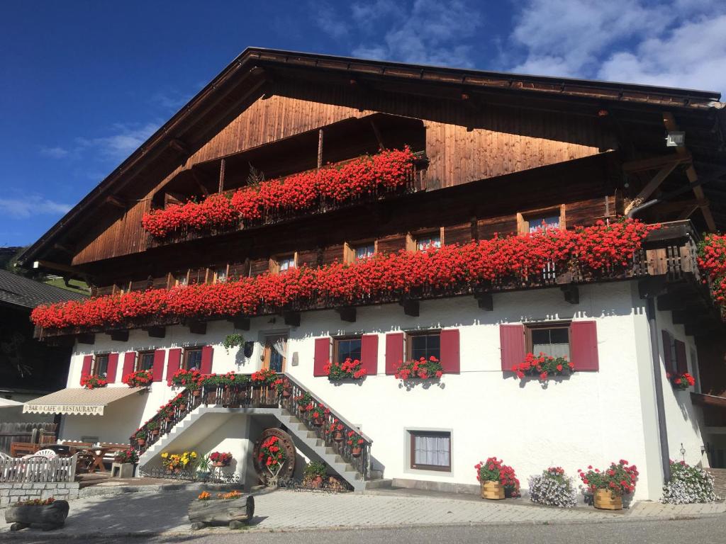 a building with red flowers on the side of it at Da Kathi in San Candido