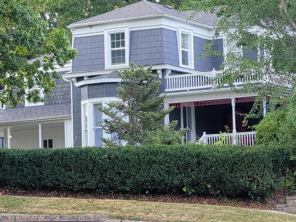 a large blue house with a tree in front of it at Stephens House-Beautiful Victorian vacation home in Maquoketa