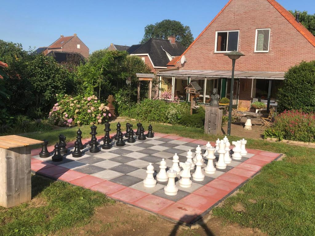 un tablero de ajedrez gigante en el césped frente a una casa en Laaker Villa nearby outlet Roermond, en Ohé en Laak