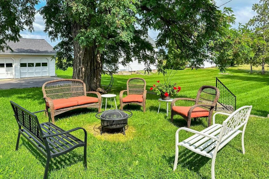 a group of chairs sitting around a fire pit in a yard at Benton Farmhouse in Penn Yan