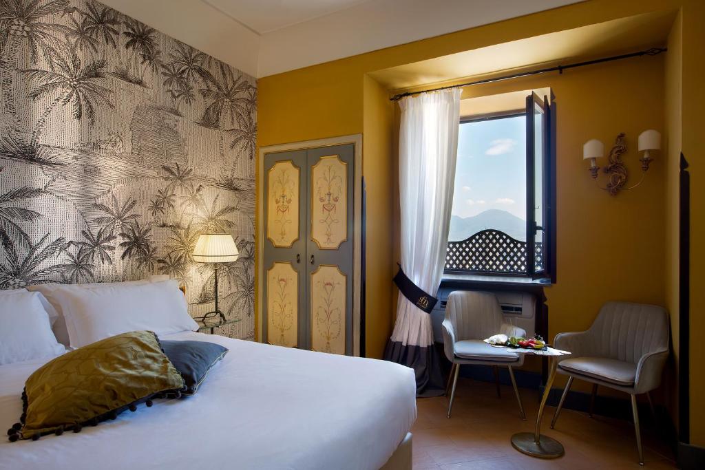 Schlafzimmer mit einem Bett, einem Fenster und einem Tisch in der Unterkunft San Francesco al Monte in Neapel