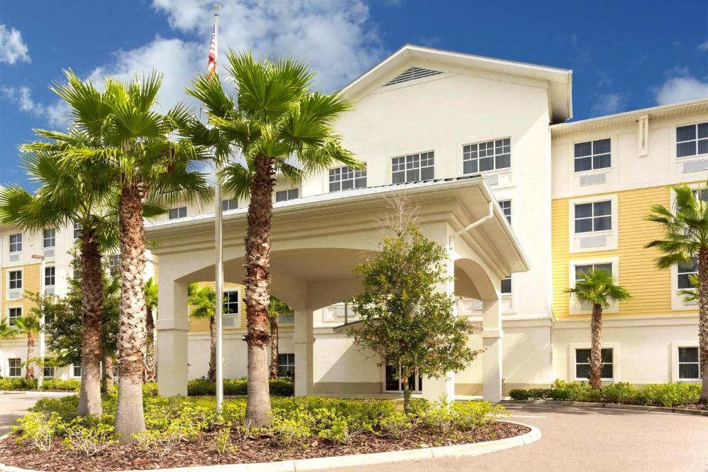 a building with palm trees in front of it at Palm Coast Hotel & Suites-I-95 in Palm Coast