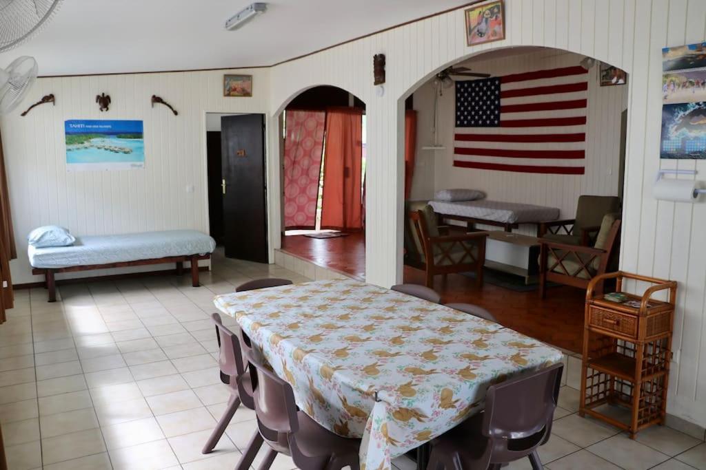 a room with a table with an american flag on the wall at Faatau House 3 bedrooms and big living room in Papeete