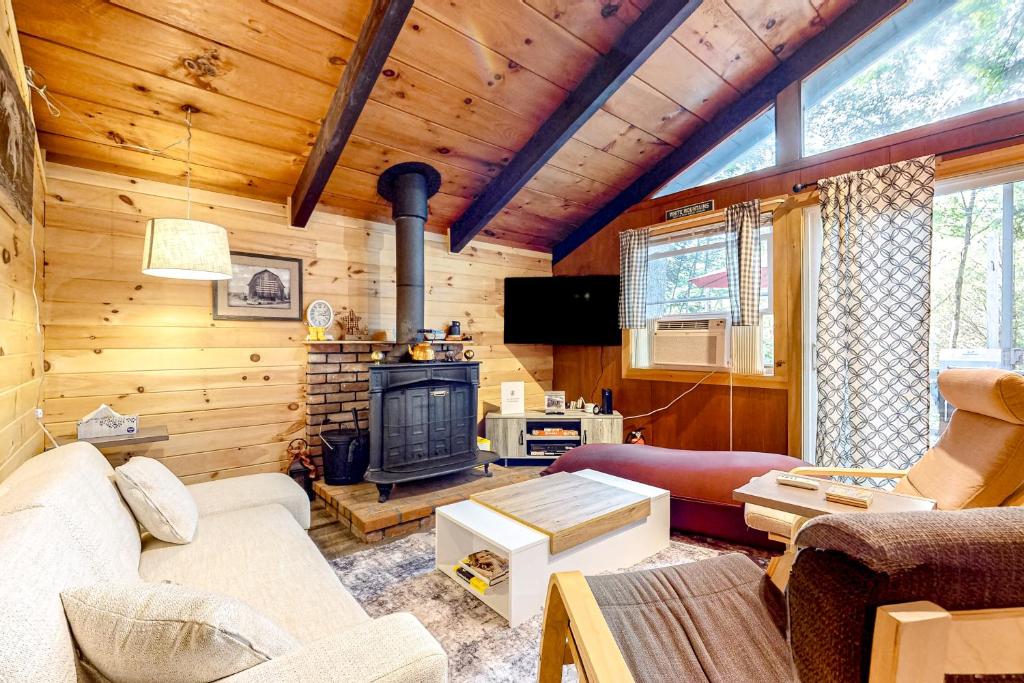 uma sala de estar com lareira num chalé de madeira em White Mountain Grove em Conway