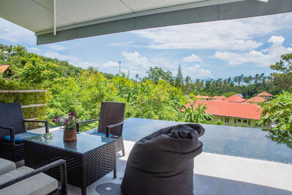 patio con mesa y vistas a la piscina en Villa Stella 16 Santi Thani Maenam, en Nathon Bay