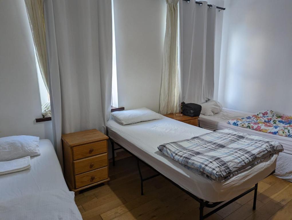 a small room with two beds and two windows at Love & Travel in Dublin