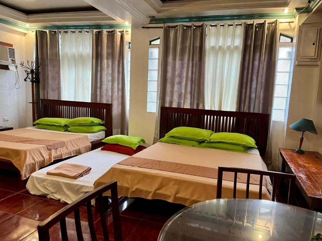 2 camas con almohadas verdes en una habitación en MARIKINA 32 sqm Studio for Transients w WiFi 40 inch TV Parking en Manila