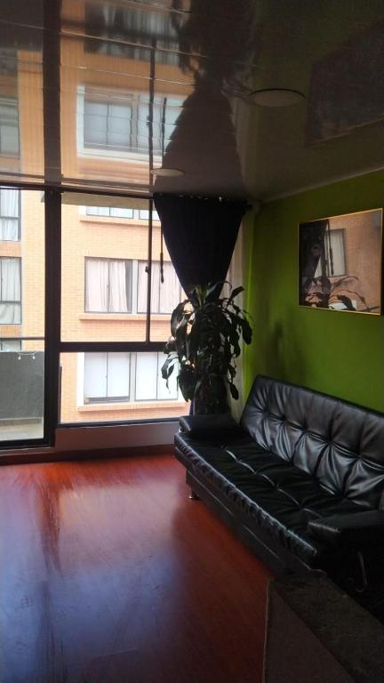 een zwarte leren bank in een kamer met een raam bij Apartamento Conjunto Residencial Yerbabuena in Soacha