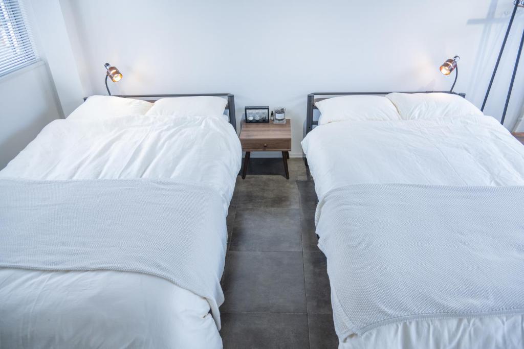 two beds sitting next to each other in a bedroom at サクラシャドウ中目黒 in Tokyo