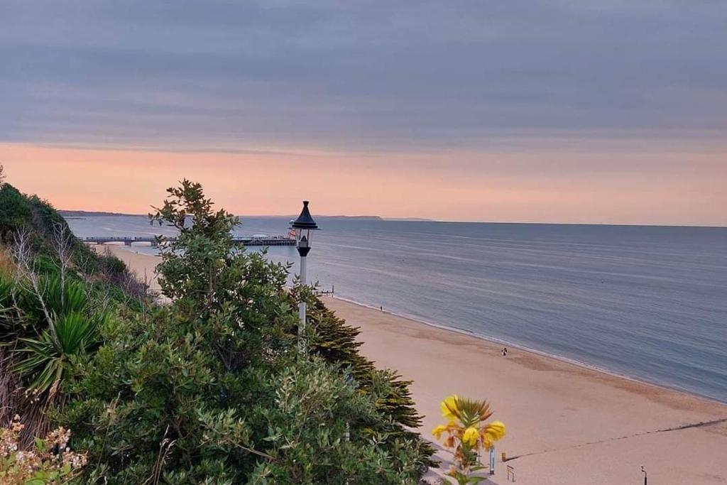 a beach with a lighthouse in the middle of the ocean at SOBO Studio in Bournemouth