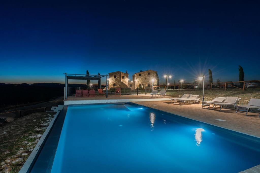 una piscina frente a una casa por la noche en Podere Fossaccio Casa Pino, en Asciano