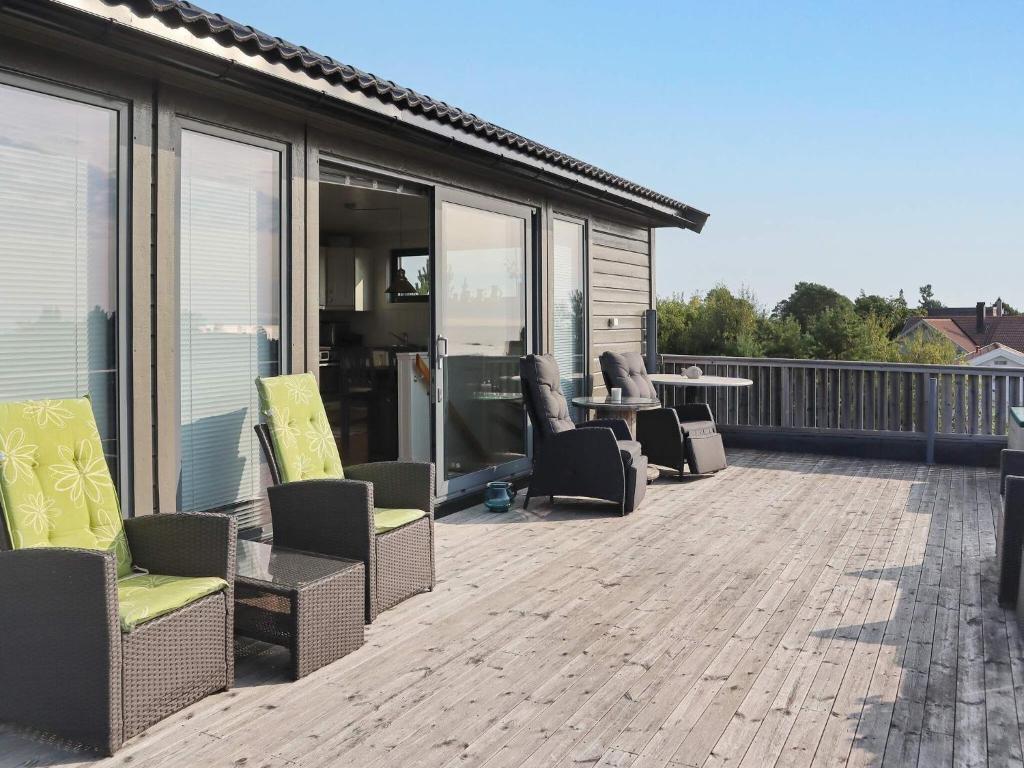 d'une terrasse avec des chaises et des tables. dans l'établissement Holiday home Søndeled, à Søndeled