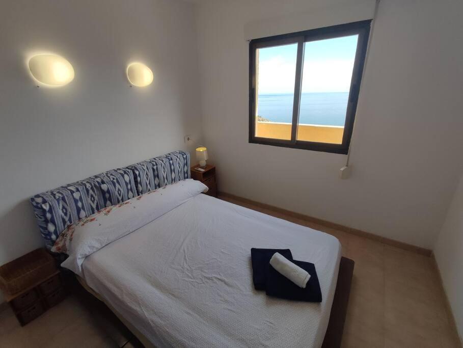 a bedroom with a bed with a view of the beach at Cumbre Moraig in Benitachell