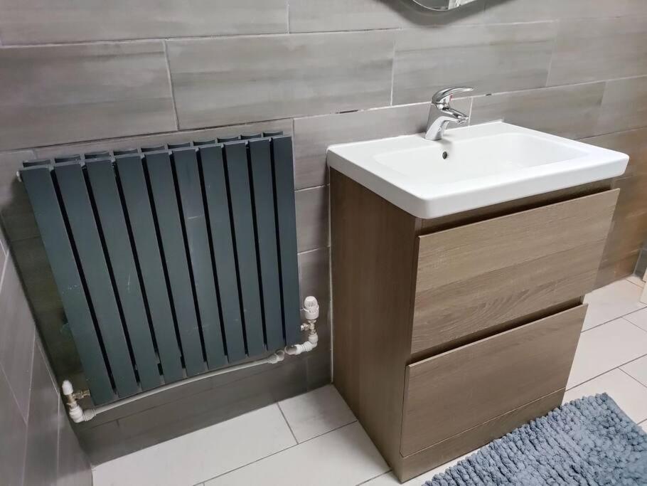 a bathroom with a sink and a radiator at Droitwich Spa centre apartment in Droitwich