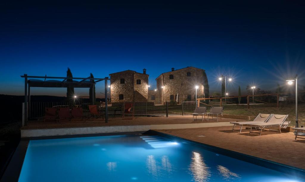 a swimming pool in front of a building at night at Podere Fossaccio Casa Fiordaliso in Asciano