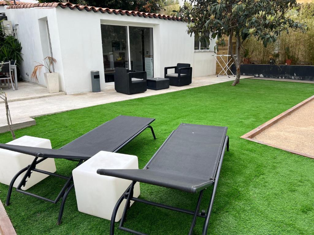拉戈德的住宿－VILLA DE VACANCES AVEC JARDIN PRIVÉ，庭院设有两张野餐桌和草坪。