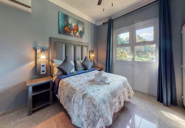 a bedroom with a large bed and a window at Caribbean Estates Lakeview Villa in Port Edward