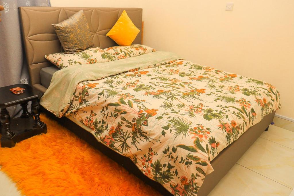 a bedroom with a bed with a floral bedspread at The Modern loft in Nairobi