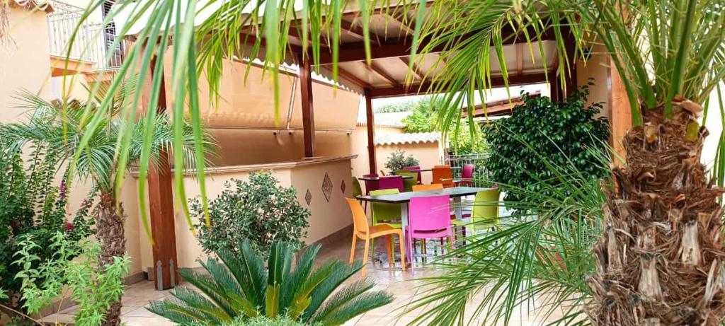 un patio con tavolo, sedie e piante di Le Falesie di Castelluzzo a Castelluzzo