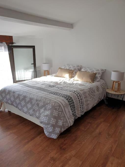 - une chambre avec un lit et deux lampes sur du parquet dans l'établissement l'escapade, à Gasny