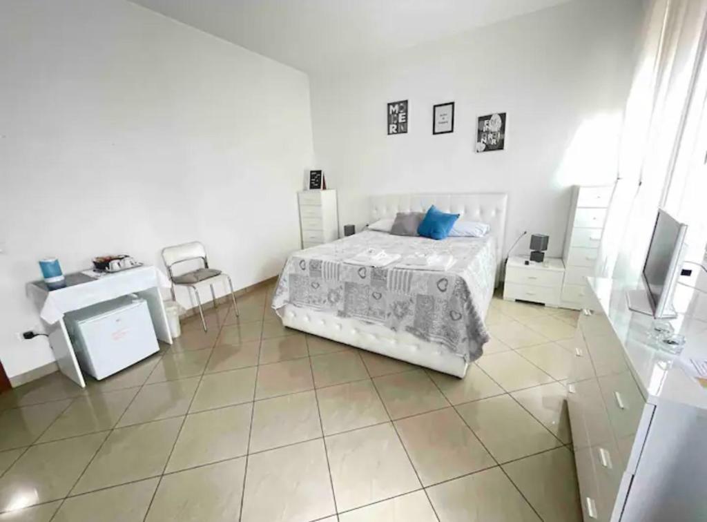 een slaapkamer met een bed, een bureau en een televisie bij Garcia Guest House in Verona