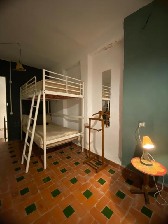 a bedroom with bunk beds and a table and a lamp at Tarbi'aat Tetaoun 44, 17th century heritage in Tetouan