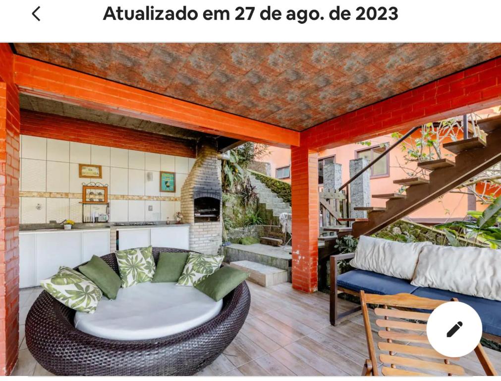 een patio met een rieten stoel en een tafel bij Vista Espetacular em Angra dos Reis in Angra dos Reis