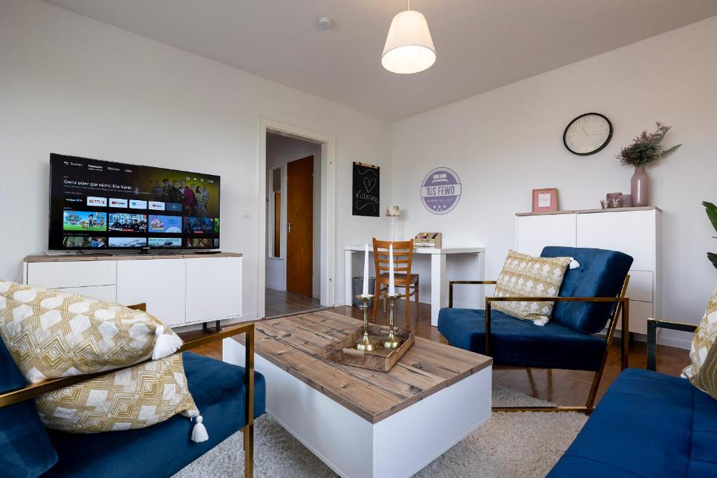 sala de estar con sillas azules y mesa en Stilvolles City-Apartment mit Komfort & Gratis WLAN, en Mönchengladbach