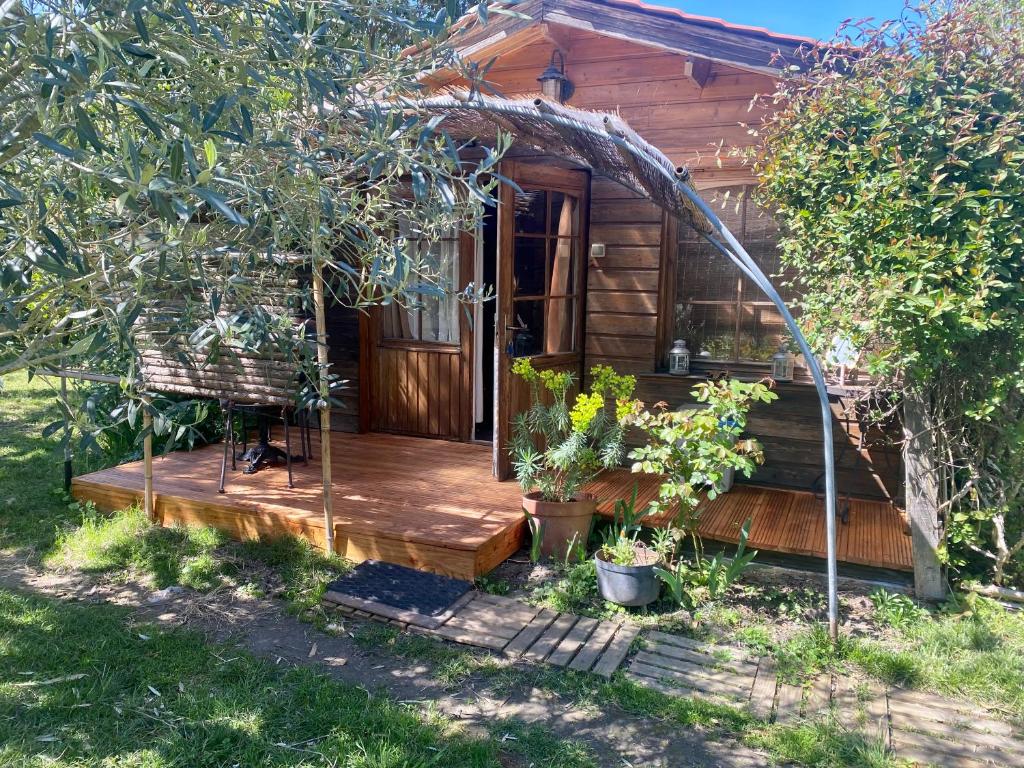 a wooden cabin with a porch and a deck at Le chalet du Jardin caché in Marmande