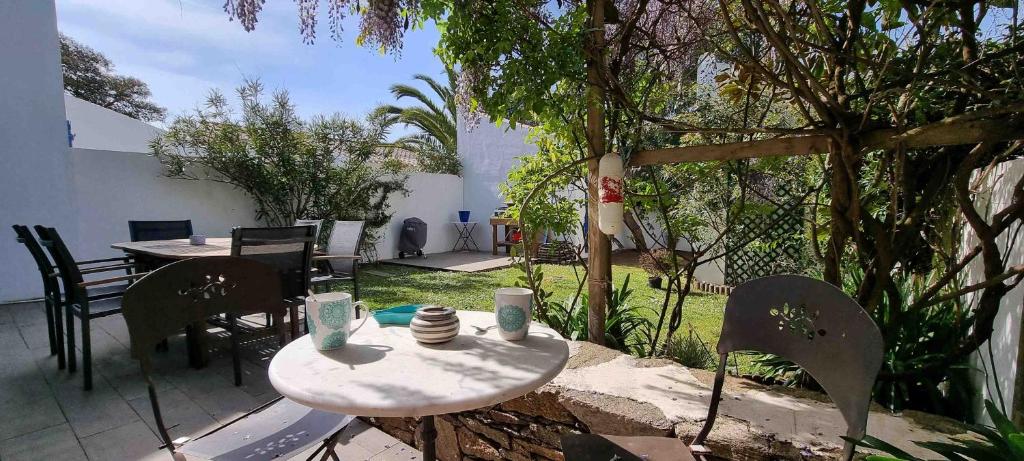 a patio with a table and chairs in a yard at Les pieds dans l'eau :KER ANNE (chez ANNE) in Port-Joinville
