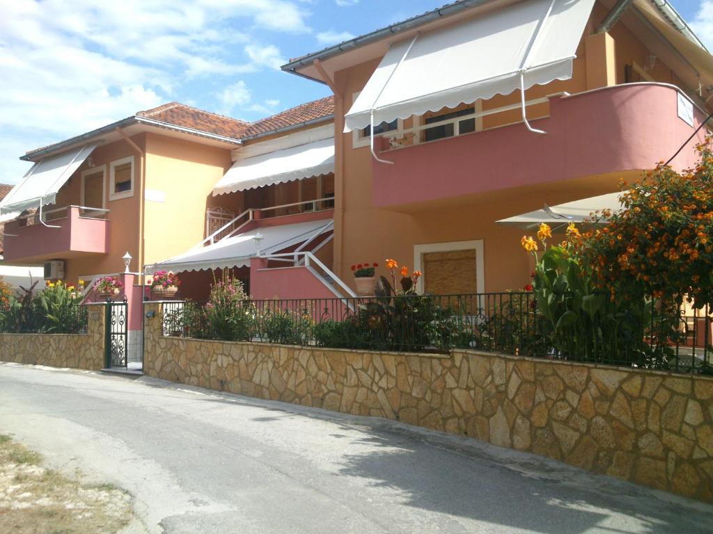 a house with pink and yellow at Villa Ira Studios - Apartments in Parga