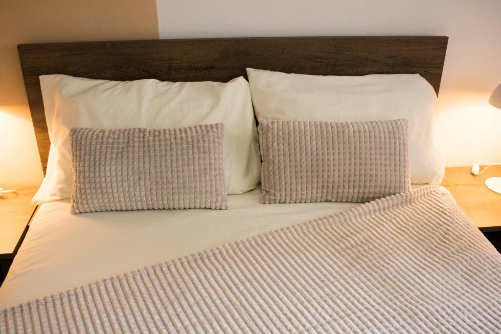 een groot bed met 2 kussens bij Getaway Tirana City Center - STAYcation Apartments in Tirana