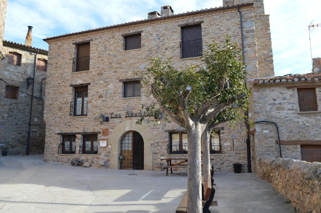 um velho edifício de pedra com uma árvore em frente em Las Abadías em San Felices
