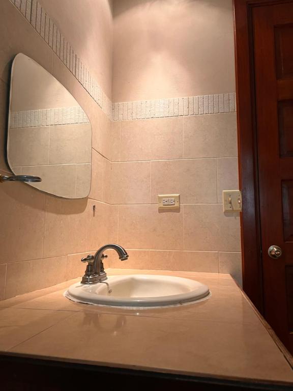 下博克特的住宿－Casa familiar en Boquete，浴室水槽设有水龙头和镜子
