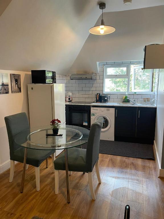 a kitchen with a glass table and a dining room at London Guest Studios 8 in London