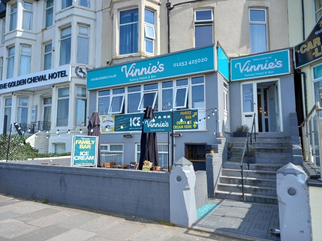 a building with blue signs on the front of it at Vinnie's Family Hotel in Blackpool