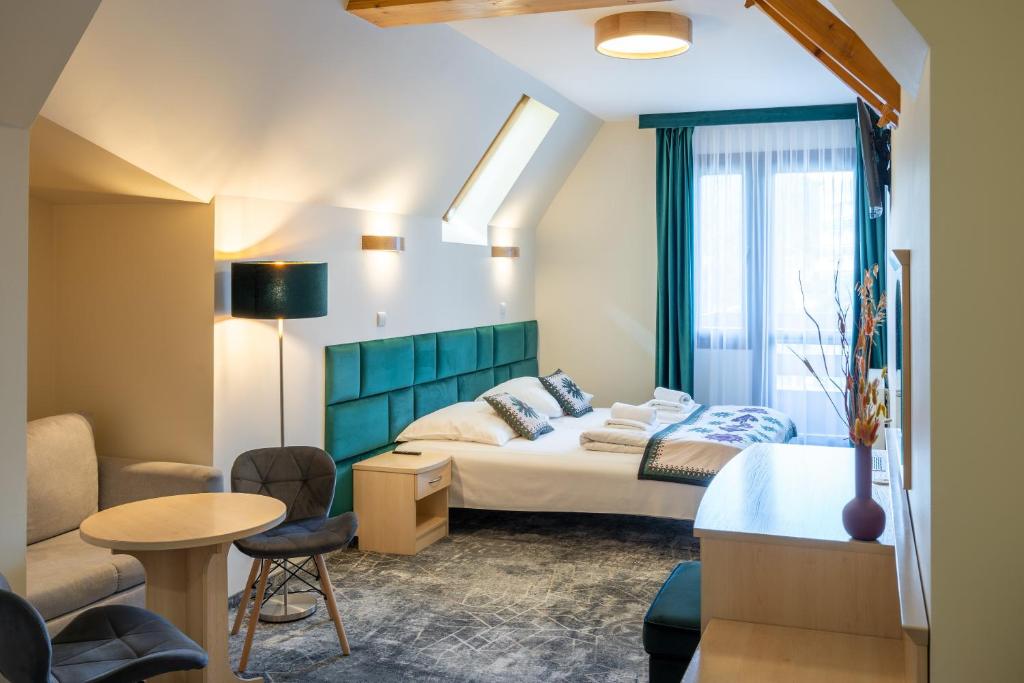 a hotel room with a bed and a table at Willa Monte Rosa in Zakopane