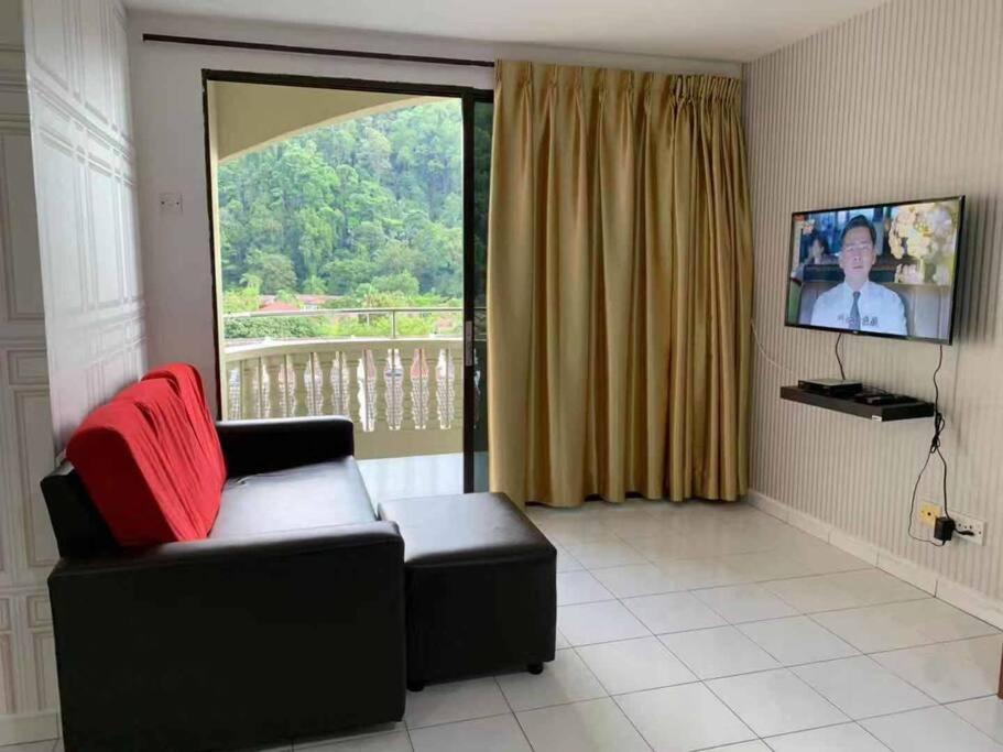 Pangkor Island CoralBay Private Apartment في كامبونغ باسير بوغاك: غرفة معيشة مع أريكة ونافذة كبيرة